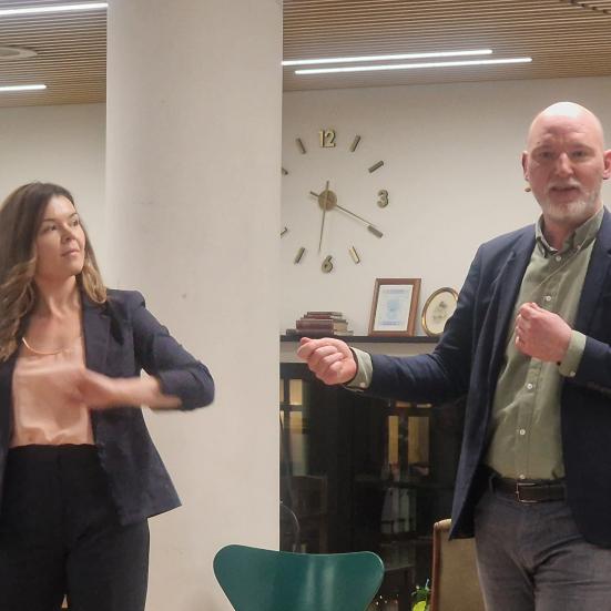 En mand og en kvinde taler ved arrangement