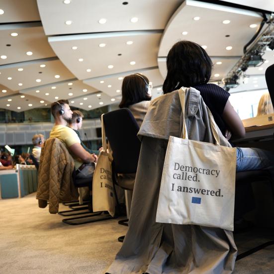 Personer i møderum og en mulepose med tekst på.