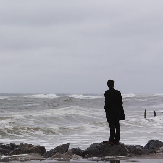 A man standing alone on the sea shore_Photo by: Eexistentialcrisiss