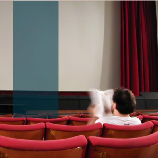 Mand læser bog i biografen