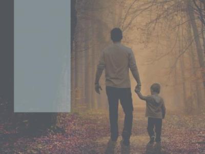 En mand med et barn i hånden ses bagfra