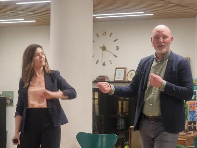 En mand og en kvinde taler ved arrangement