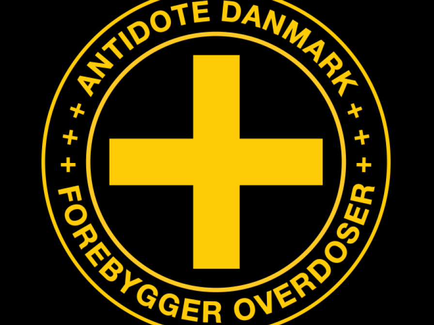 Antidote Danmarks logo - et gult kryds med to cirkler omkring