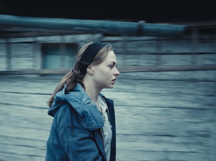 gående kvinde, går ved siden af et skur