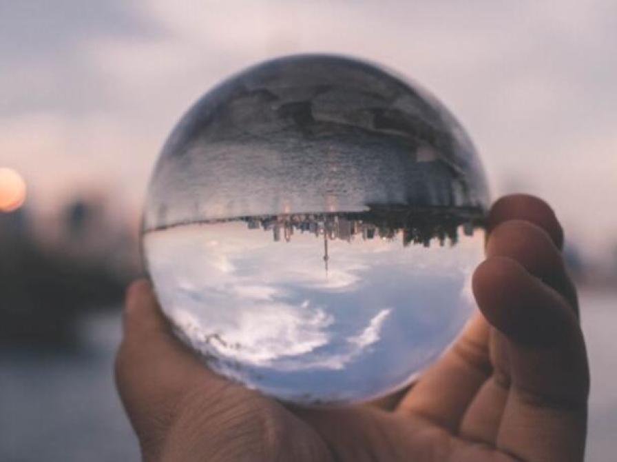 Billede af en by i en klode holdt af en hånd